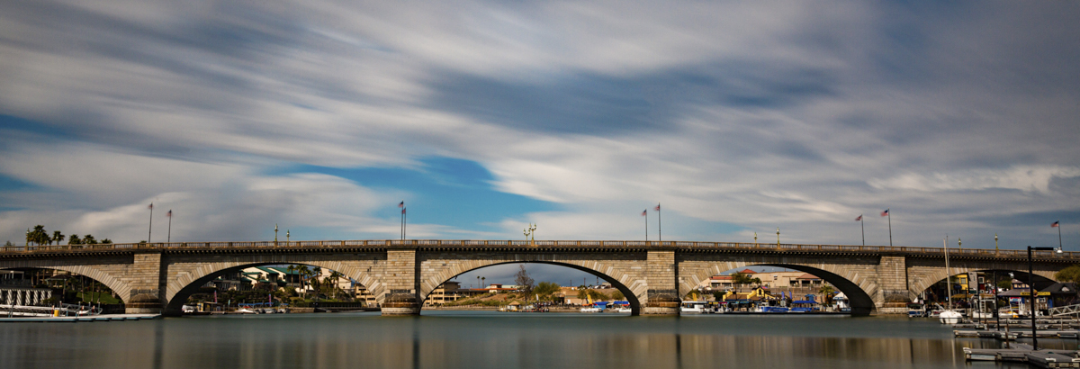 Vibrant and sunny London Bridge across greenish blue water